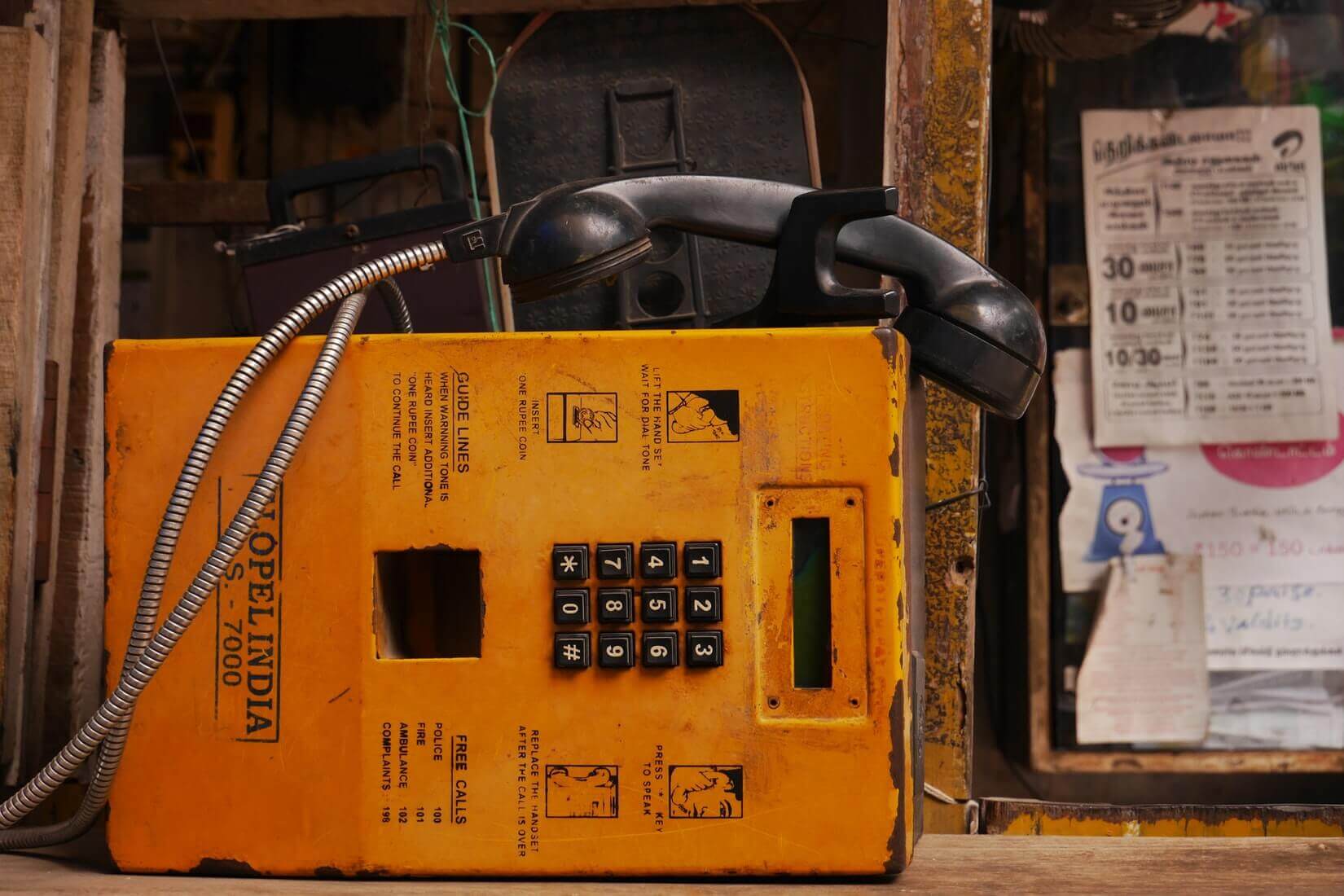 Старый телефон-автомат, лежащий на боку